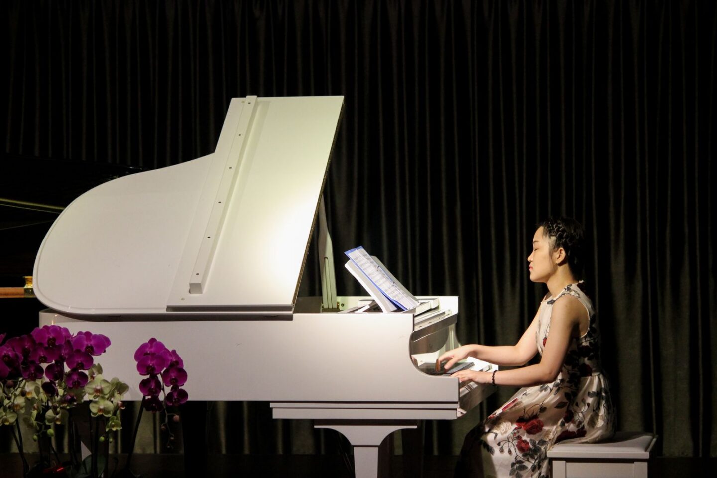Pianista che suona un pianoforte a coda bianco